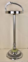 Full view of the vintage mid century chrome ashtray stand with curved handle and round ashtray holder.