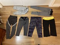 Six pairs of girl/teen tights laid out on floor in single row showing full range of colors and styles.