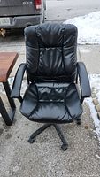 Front view of black computer chair showing padded seat, backrest, and armrests.