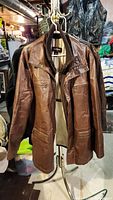 Front view of the brown Danier leather jacket showing overall condition, collar, and zipper details.