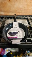 Top view of the new 12-inch IKO frying pan showing black speckled ceramic interior, handle and product label.