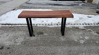 Front view of wood slab table showing natural wood grain top and metal legs.
