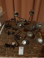 Top down view of four metal candelabras arranged on a wooden surface showcasing their ornate design and wear.