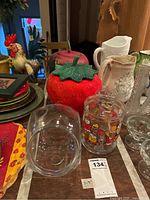 Overview of all cookie jars and glass jar on table with other items around
