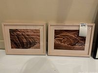 Two framed photographs side by side showing red rock formations in blush pink frames and mats.