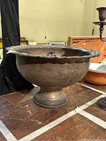 Side view of large silver plated punch bowl showing tarnish and decorative rim.