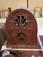 Front view of vintage Tempelton cathedral radio showing decorative wooden speaker grille and central tuning dial with two knobs on wooden cabinet.