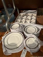 Stacks of dinner plates, salad plates and saucers wrapped in quilted storage containers