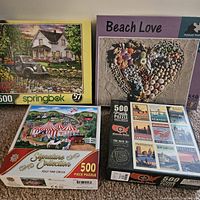 Photo of four 500-piece jigsaw puzzles with distinct themes shown in their box covers.