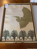Full view of the framed art print showing a heron with ornamental foliage and textured circular background.