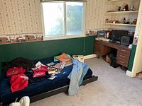Overall view of daybed surface with apparel, folders and desk in background
