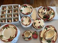 Full view of china set including stacked plates, covered bowls, platters, gravy boat, and small condiment holders.