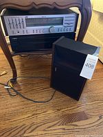 JVC stereo receiver, Yamaha CD player stacked on a wooden side table with Bose speaker to the right on hardwood floor, cables visible.