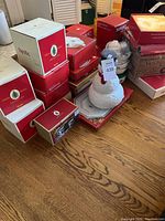 Group photo of boxed Spode Christmas Tree items including teapot shaped like bird, plates, and boxed sets.