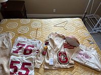 Lot overview showing sweatshirt, cardigan and football on mattress