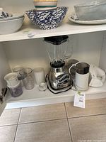 Oster blender, Hamilton Beach hand mixer, coffee grinder, Braun small mixer/blender on kitchen shelf