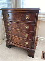 Front view of mahogany-finish four-drawer cabinet showing brass ring pulls