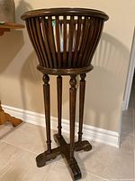 Full view of wooden plant stand showing basket top and four legs