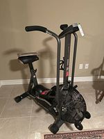 Side view of full Schwinn Airdyne bike showing padded seat, fan wheel, frame, and dual-position handles