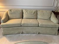 Full front view of the sofa showing three cushions and skirted base
