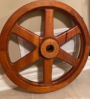 Front view of the six-spoked wooden wheel showing full circular shape and six sturdy spokes with raised identifier number LK909 on one spoke.