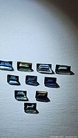 Photo showing 10 baguette cut sapphires in multicolored blue and green hues set against a light background.