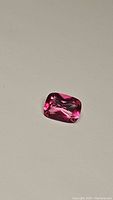 Top view of the hot pink cushion cut topaz showing deep vibrant pink color and well-formed facets.
