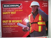 Close-up of one Benchmark high visibility safety vest package showing product features including reflective lightweight mesh, five point tear away, hook and loop closures, one size fits all, new in wrapper.