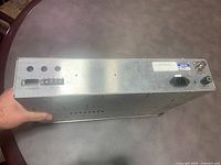 Photo of the full metal chassis receiver unit showing ports and connectors on the back panel.