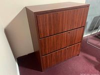 Front view of the wood-finish three drawer office cabinet showing entire unit and drawer fronts.