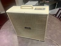 Front view of the Weston floor fan showing grille, handle and control panel.