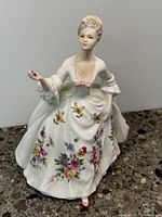 Front and side view of Royal Doulton Diana bone china figurine showing detailed floral dress and painted features.