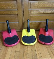 Front view of three Zipfy mini luges showing handles and seats.