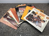 Photo showing the array of 8 assorted Harry Chapin vinyl albums fanned out on a surface, details of cover art visible.