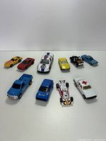 Ten assorted toy cars arranged in two rows against a plain background.