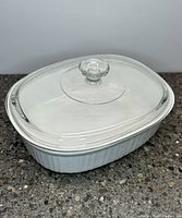 Closed CorningWare white stoneware baking dish with clear Pyrex glass lid in place