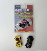 Front view of all three Darda wind-up toys including one new in package and two loose cars.
