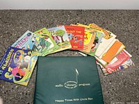 Spread of colorful children's vinyl records with attached storybooks showing various titles including Disney and holiday themes.