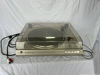 Front angle view of the Dual CS 620 Q turntable with dust cover, control buttons, and cables visible.