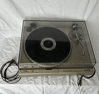 Front angled view of Kenwood KD-3100 turntable with dust cover on and power cord.