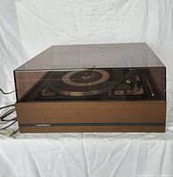 Front angled view of Noresco Dual 1009 turntable showing wooden base, dust cover, platter and tonearm.