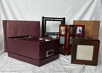 Photo showing all items in the lot including photo album boxes, scrapbooks, and various frames grouped together on a white cloth.