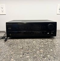 Front view of black vintage Pioneer stereo receiver with buttons and knobs, model SX-253R on display.