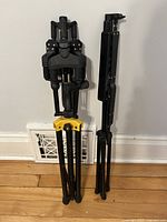 Folded sheet music stand and foldable guitar rack placed against a wall.