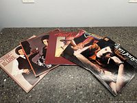 Top-down photo showing six different Tom Jones vinyl record covers fanned out on a countertop, each with unique artwork.