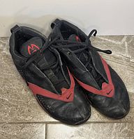 Top view of the pair of black and red Nike Zoom Air basketball shoes showing wear and creasing on the toe box and vamp area, laced up showing the tongue logo.