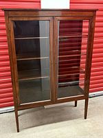 Front view of cherrywood china cabinet showing glass-paneled doors and interior shelves