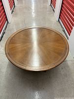 Top view showing round tabletop with sunburst wood grain and decorative edge inlay.