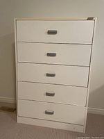 Front view of the white 5-drawer highboy dresser with gray handles, showing minimal styling and good structural form.