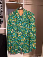 Green patterned suit jacket hanging on hanger